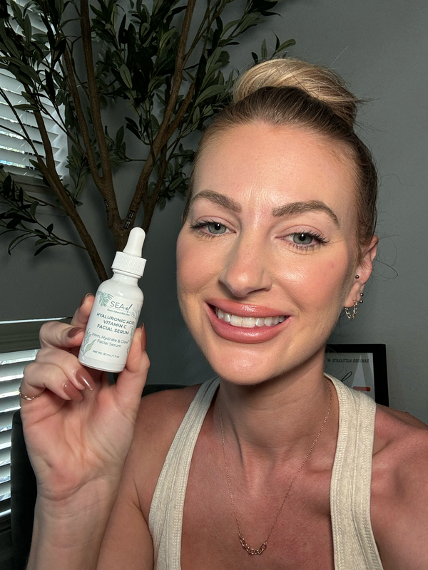 Image of girl smiling, with a serum bottle near her face.