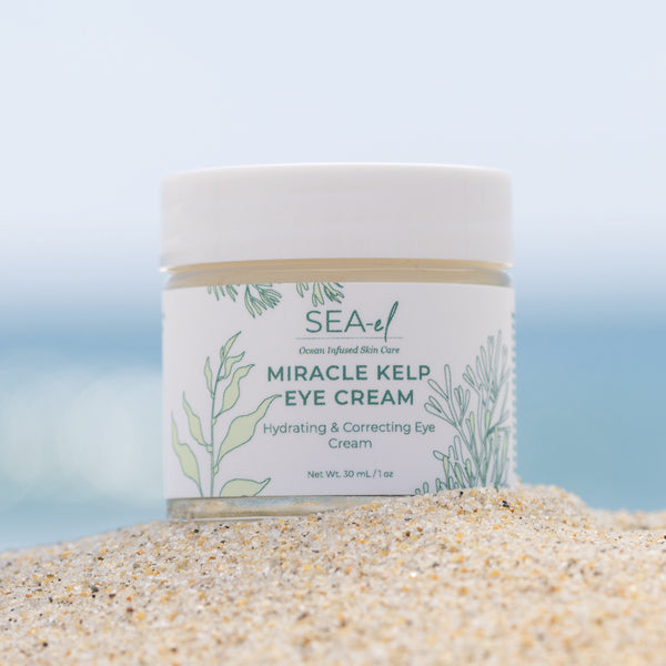 Image of our Eye Cream sitting on the sand at the beach.