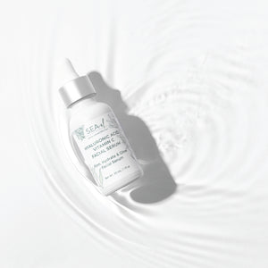 Image of our Hyaluronic Acid Vitamin C Serum on top of water with a white backround.