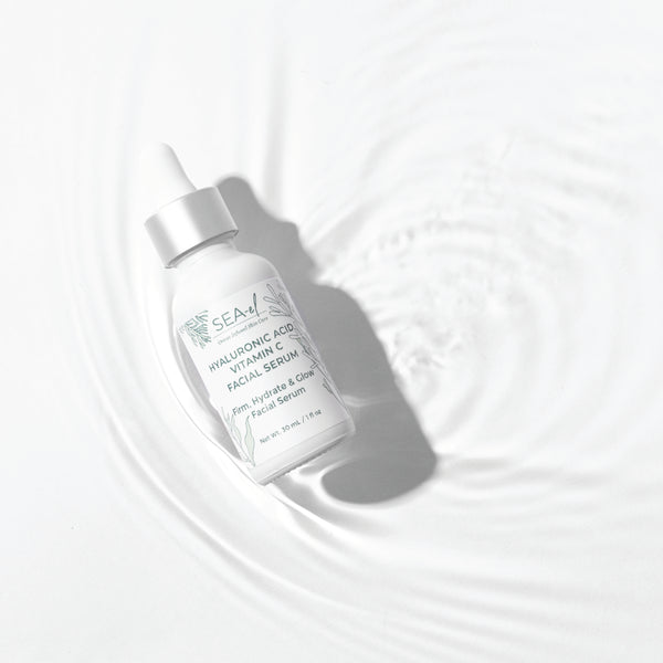Image of our Hyaluronic Acid Vitamin C Serum on top of water with a white backround.