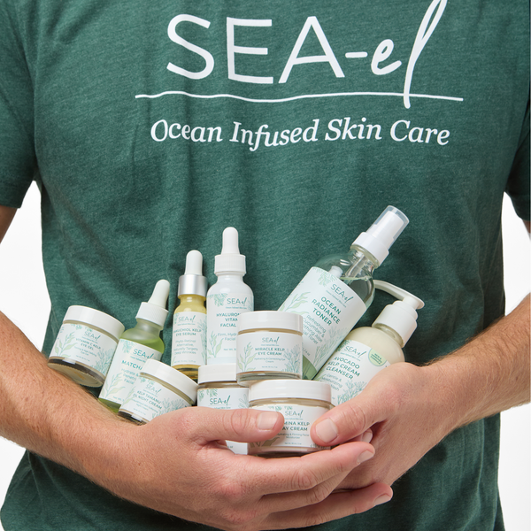 Image of a man holding a lot of Sea el Skincare products in his hands.