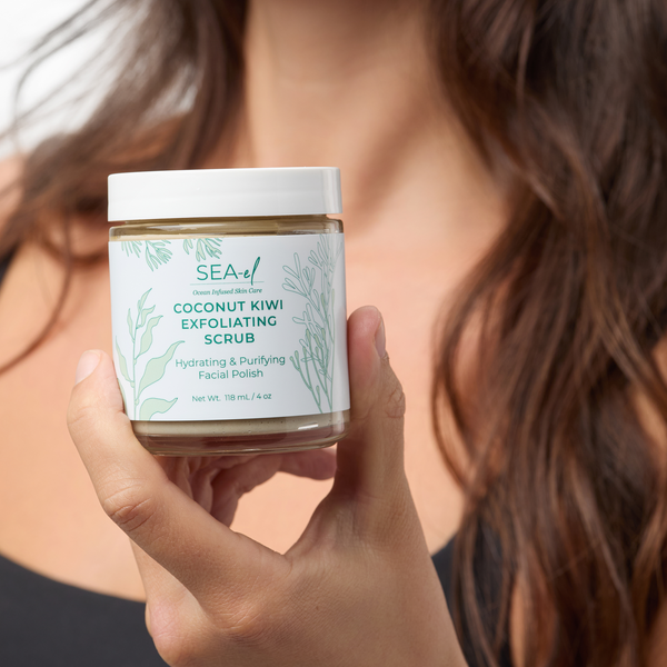 Image of a girl holding our Coconut Kiwi Scrub in her hand, showing the products label.