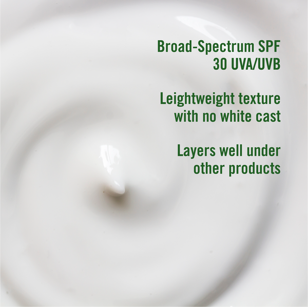 Close-up of a white cream with green text detailing SPF and texture properties.