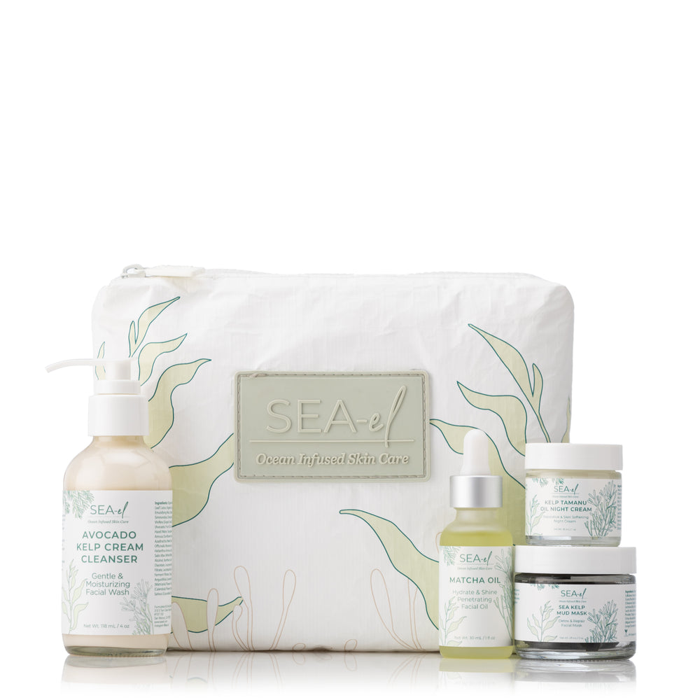 A collection of skincare products including a bottle of Matcha Oil, a Facial Cleanser, a jar of Night Cream, and a Sea Kelp Mud Mask, all arranged in front of a white bag decorated with green seaweed illustrations.