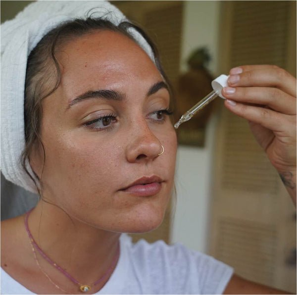 Girl Applying our Matcha Oil on her face.