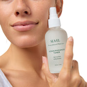 Girl holding Toner next to her face with a smile.
