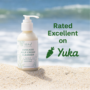 Bottle of Sea el skincare cleanser, Avocado Kelp Cream Cleanser on sand with ocean background and 'Yuka' rating text. Ranked excellent on Yuka.